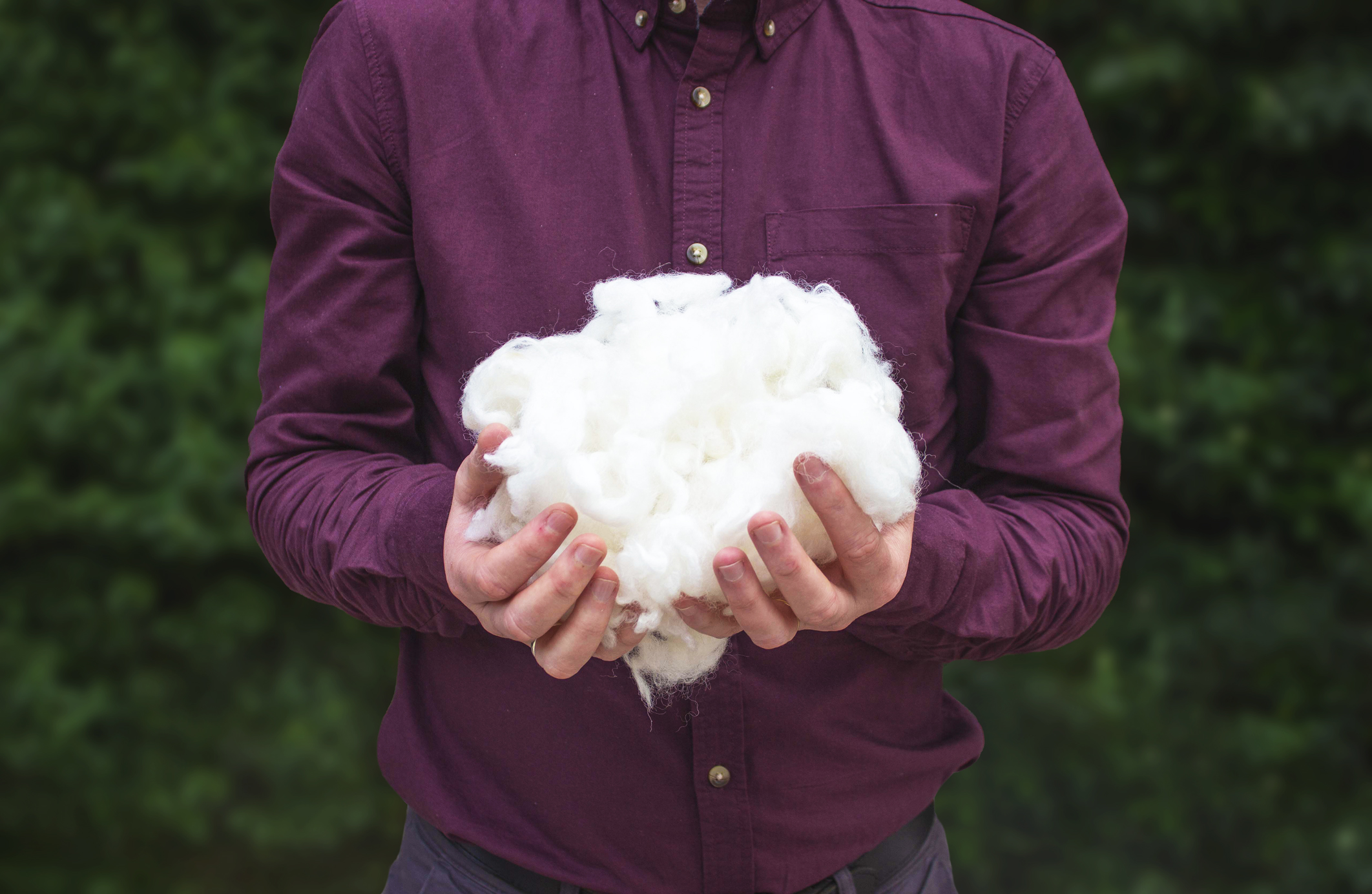 a man holding wool in his hands